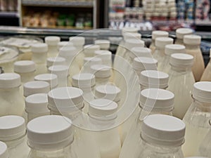 Bottled milk on a shelf in a supermarket. Many bottles