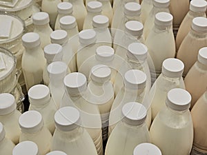 Bottled milk on a shelf in a supermarket. Many bottles