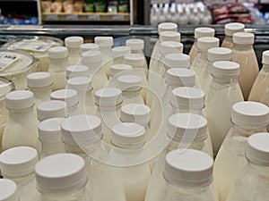 Bottled milk on a shelf in a supermarket. Many bottles