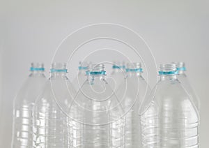 Bottlenecks of a pack of liter and a half of empty mineral water without caps just with the sealing ring on a white