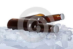 Bottles of beer on ice cubes against white