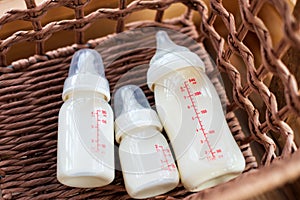 Bottles with breast milk for baby in straw basket.