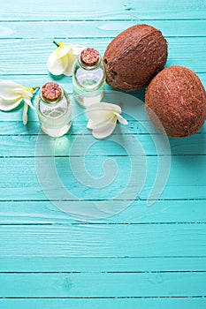 Bottles with coconut oil on bright wooden background.