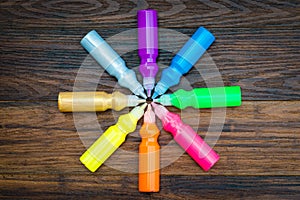 Bottles with colorful dry pigments on wooden background