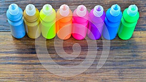 Bottles with colorful dry pigments on wooden background