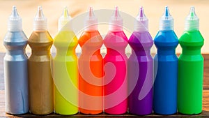 Bottles with colorful dry pigments on wooden background