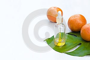 Bottles with cosmetic natural  products  and vitamin C serum on green leav,  on white background. Beauty salon treatments concept. photo