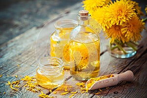 Bottles of dandelion tincture or oil and flower bunch