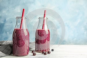 Bottles with delicious acai smoothie on table