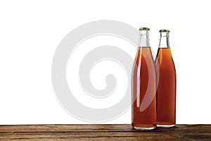 Bottles of delicious kvass on wooden table against white background
