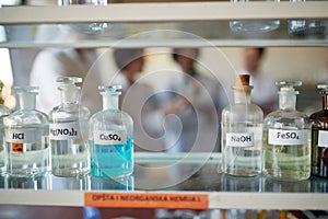 Bottles with different chemicals on the shelf in the laboratory. Science, chemistry, lab, people