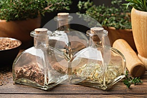 Bottles of dry herbs for preparing healing infusions or tinctures. Medicinal plants on background. Herbal medicine