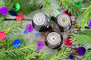 Bottles of essential oil and fir branches. Christmas aromatherapy and spa concept.