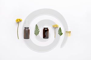 Bottles of essential oil with flowers and herbs. Alternative medicine concept.