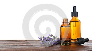 Bottles of essential oil and lavender flowers on wooden table