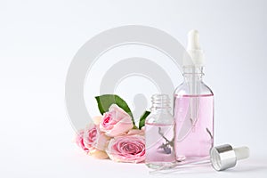 Bottles of essential oil and  on white background