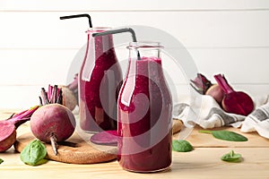 Bottles of fresh beet smoothie on table
