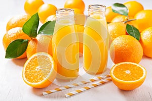 Bottles of fresh orange juice with fresh fruits