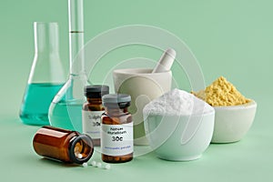 Bottles of homeopathic drugs - Natrum muriaticum, Sulphur, substances and ingredients for preparation of homeopathic remedies.