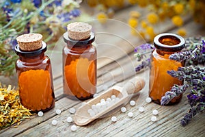 Bottles of homeopathic globules and healing herbs. Homeopathy medicine.