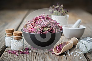 Bottles of homeopathic globules, healthy echinacea flowers in bowl and mortars on wooden table. Homeopathy photo