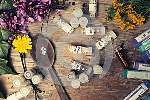 Bottles with homeopathy globules and spoon, decorated with flowe photo