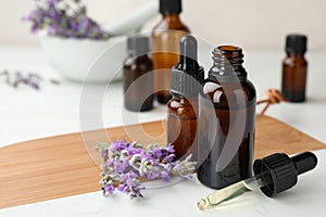 Bottles with natural lavender essential oil on wooden board