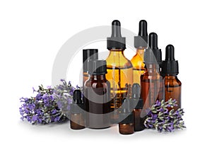 Bottles with natural lavender oil and flowers on white
