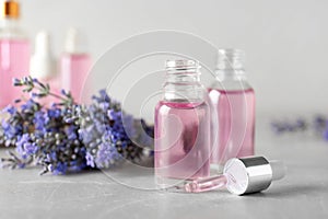 Bottles of  oil and lavender flowers on stone table