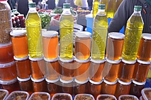 Bottles of olive oil and glass bottles with honey on a stand and stall in bazaar turkey antalya