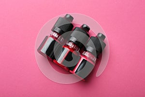 Bottles of pigments for permanent makeup on pink background, top view photo