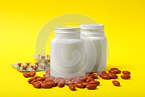 Bottles with pills on yellow background. Anemia treatment