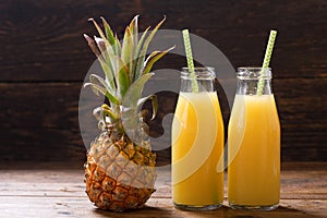 Bottles of pineapple juice with fresh fruits