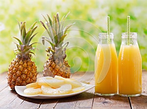 Bottles of pineapple juice with fresh fruits