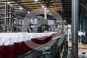 Bottles of red soda in the factory line.