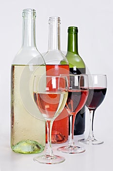 Bottles of red, white and rose wine with glasses