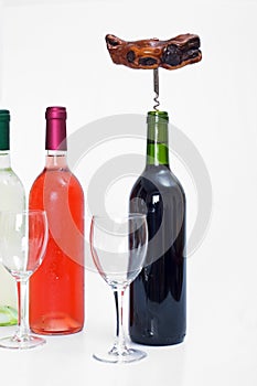 Bottles of red, white and rose wine with glasses and a corkscrew
