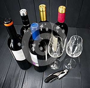 Bottles of red wine with wine glasses and a corkscrew for tasting