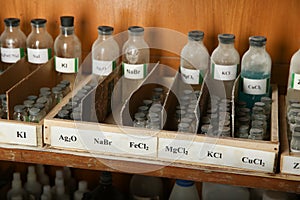 Bottles with solutions of NaBr, FeCl2, MgCl2 on the shelf of the chemical cabinet