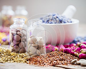 Bottles of tablets, healing herbs and mortar with lavender