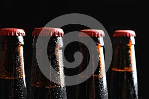 Bottles of tasty cold beer on black backgroun