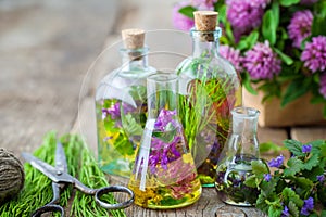 Bottles of tincture of healing herbs, scissors and medicinal herbs.