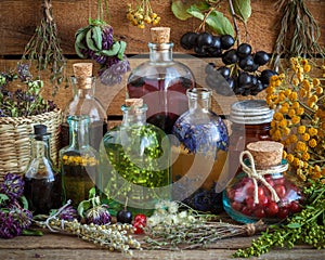 Bottles of tincture, potion, oil, healthy berries and herbs photo