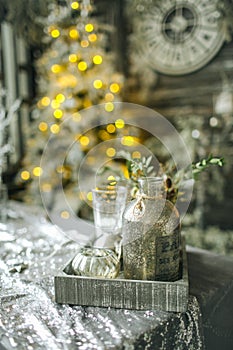 Bottles and tree toys in vintage Christmas decorated room