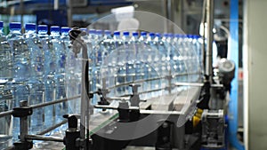 Bottles with a volume of 1.5 liters of water moves along the conveyor. Production of mineral water in the shop of the