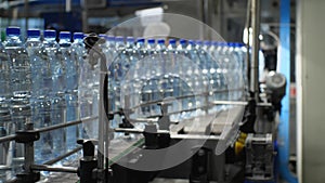 Bottles with a volume of 1.5 liters of water moves along the conveyor. Production of mineral water in the shop of the food industr