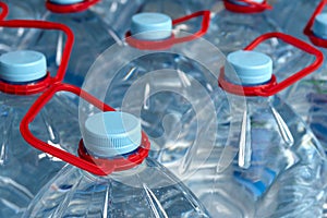 Bottles with water. Blue cover and red handle. Drinking water in five-liter bottles. Selective focus