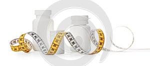Bottles of weight loss pills and measuring tape