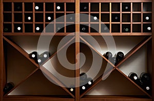 Bottles of white and red wine on a wooden shelf with books in pr