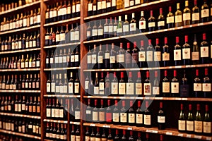 Bottles of wine for sale on shelves of retail shop supermarket